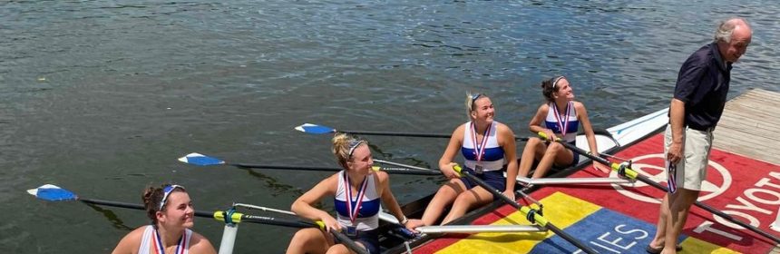 Four athletes in a boat on a river during a rowing competition