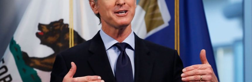 Califormia governor Newsom giving a speech in front of flags