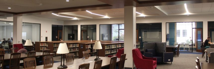 Interior of library with large wooden tables and bookcases