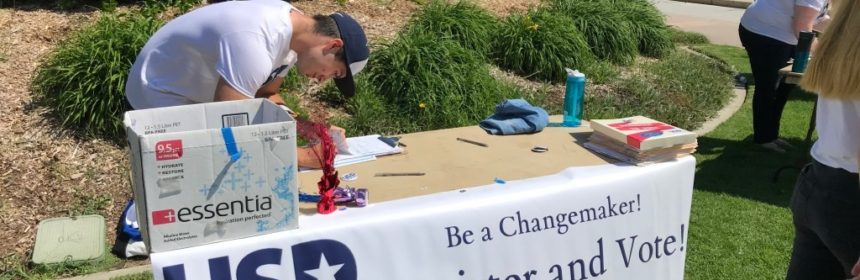 USD Votes table on campus with banner reading "Register and Vote"