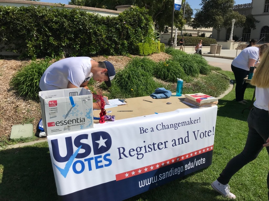 USD Votes table on campus with banner reading "Register and Vote"