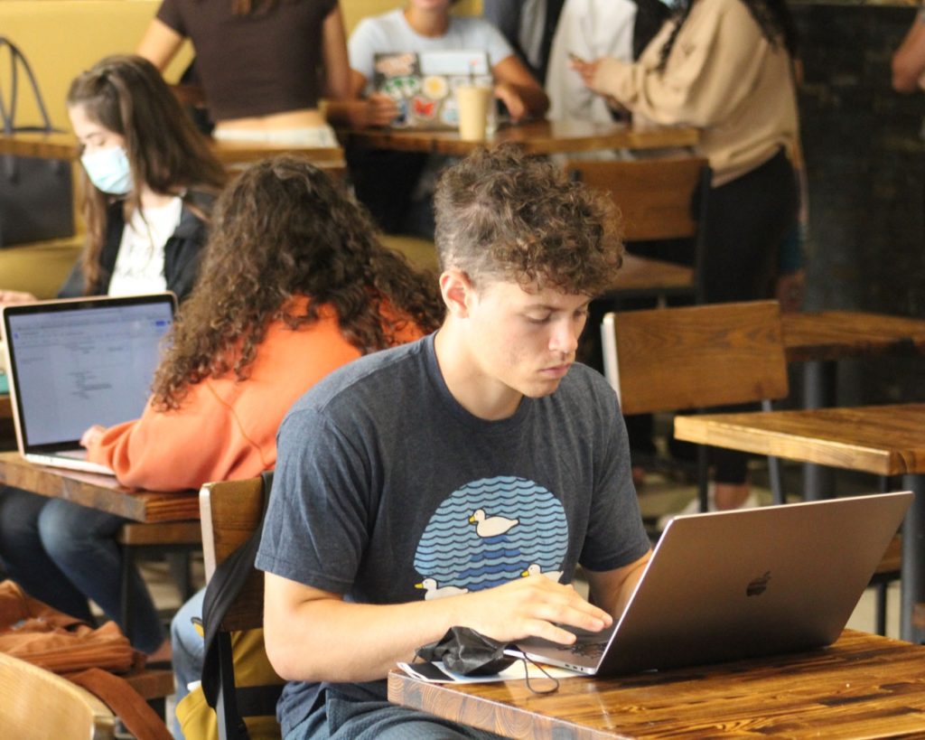 Students studying on laptops in coffee shop