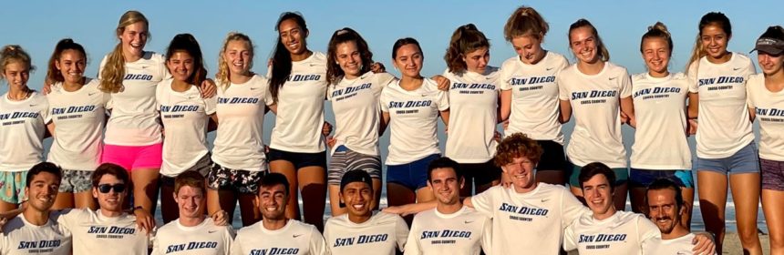 Team picture of student cross-country athletes lined up, all wearing white USD t-shirts