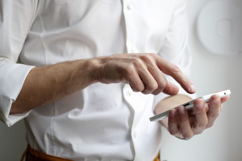 Close up view of person's hands using their cell phone