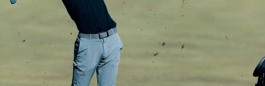 Man swinging golf club after hitting the ball