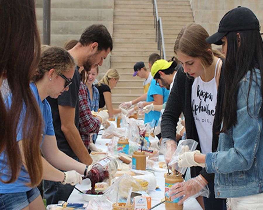 Students gathered around table making food