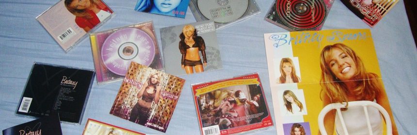 Britney Spears CDs and posters laid out on a bed