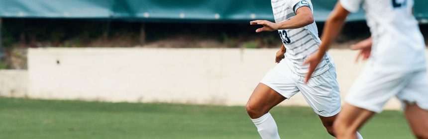 Male soccer player running for the ball during a game