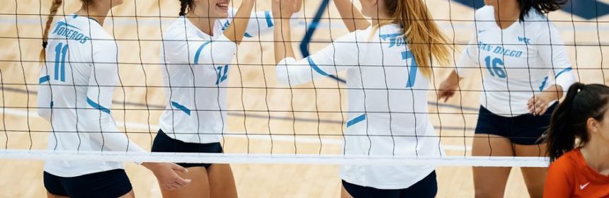 Female volleyball players high-fiving during a game