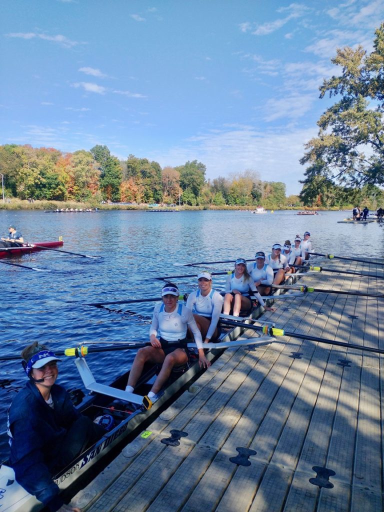 USD rowing team in long rowing boat floating on body of water