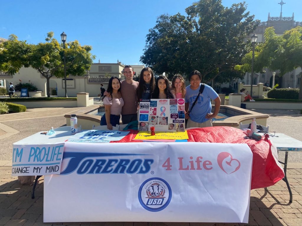 Table with students and banner reading "Toreros 4 Life"