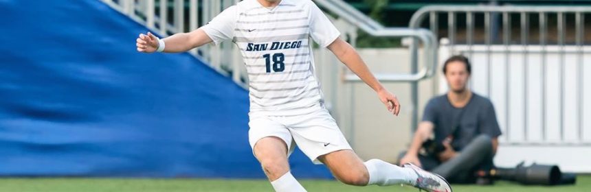Men's soccer player kicking the ball during a game