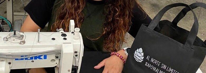 Student sewing black tote bags