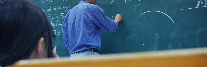 Professor writing on chalkboarrd