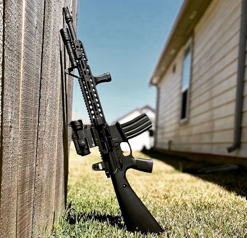 Automatic rifle propped up against building