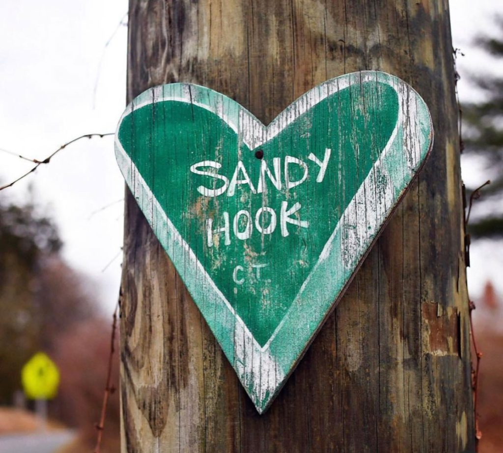 Wooden heart reading "Sandy Hook" nailed to a tree