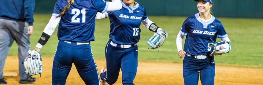Female softball players high-fiving during a game