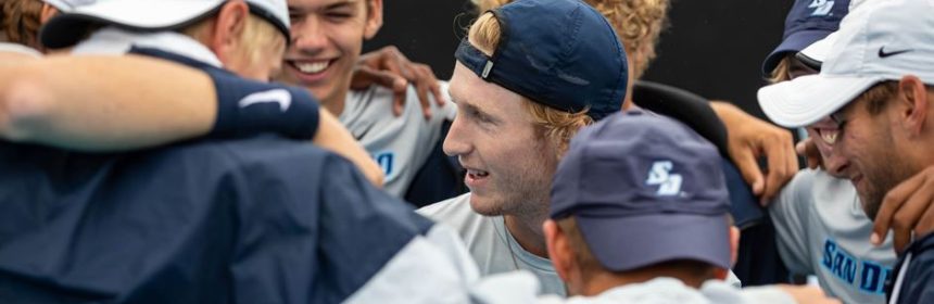 Men's tennis team huddling together after a match