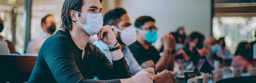 masked man in a classroom with other students