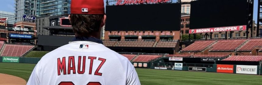 back of person in a red hat with a jersey reading Mautz 22