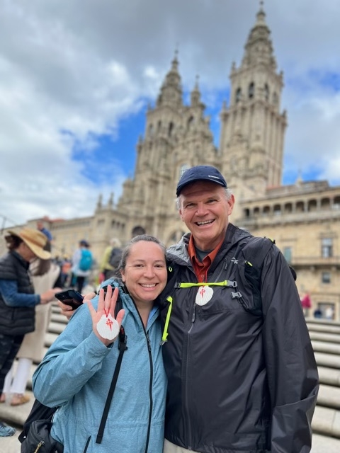 man holding woman smiling at camera with building in the back
