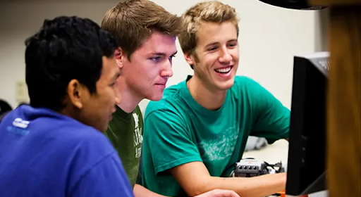 three boys looking at computer