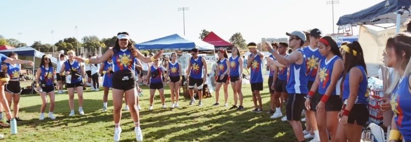 people in matching tanks in a circle with someone jumping in the middle