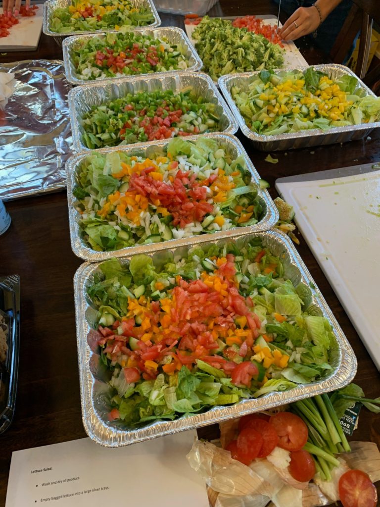 trays of lettuce, tomatoes, and other vegetables on a table